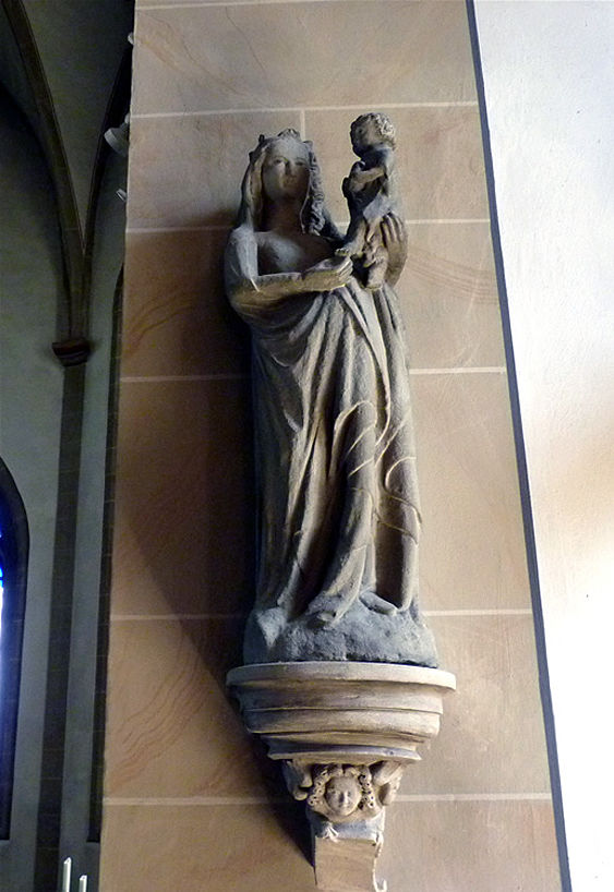 14. Madonna: Gotische Sandsteinplastik von ca. 1340. Das Jesuskind hält einen Vogel in den Händen. Ursprünglich stand sie am südlichen Strebefeiler außen an der Kirche.